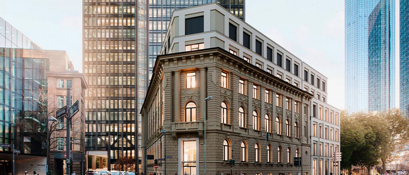 Historisches Gebäude zwischen modernen Hochhäusern in einer Innenstadt.